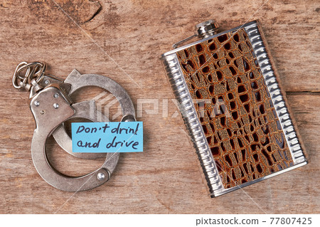 Metal handcuffs, paper message, hip flask. Metal handcuffs, paper message, hip flask. 77807425
