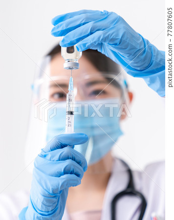 Doctor pulling vaccine from vial Doctor pulling vaccine from vial 77807605