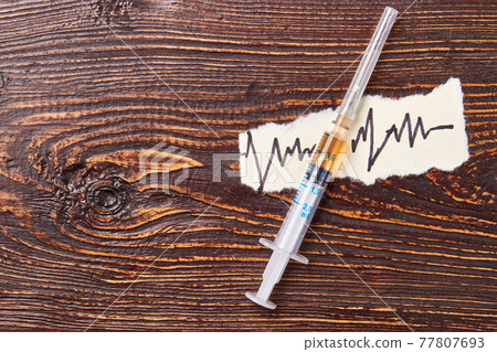 Syringe with liquid, paper note. Syringe with liquid, paper note. 77807693