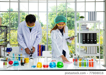 Asian biological research scientist man and woman setting up working together 77808018