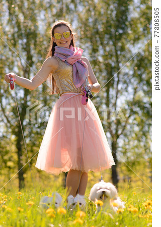 Young woman with her dog. Puppy white dog is running with it's owner. Concept about friendship, animal and freedom. Young woman with her dog. Puppy white dog is running with it's owner. Concept about friendship, animal and freedom. 77808505