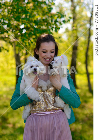 Young woman with her dog. Puppy white dog is running with it's owner. Concept about friendship, animal and freedom. Young woman with her dog. Puppy white dog is running with it's owner. Concept about friendship, animal and freedom. 77808511