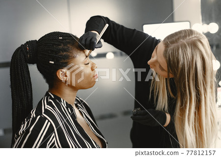 African girl doing eyebrow correction 77812157