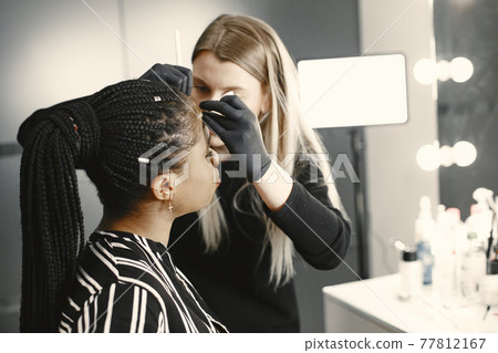 African girl doing eyebrow correction 77812167
