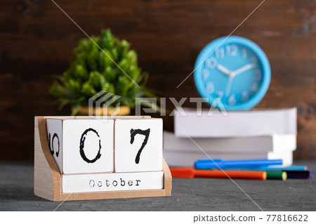 October 07th. October 07 wooden cube calendar with blur objects on background. 77816622