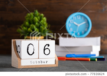 October 06th. October 06 wooden cube calendar with blur objects on background. October 06th. October 06 wooden cube calendar with blur objects on background. 77816624