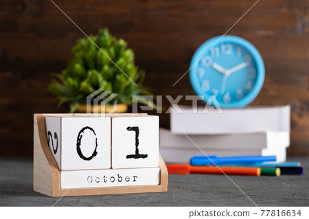 October 01st. October 01 wooden cube calendar with blur objects on background. October 01st. October 01 wooden cube calendar with blur objects on background. 77816634