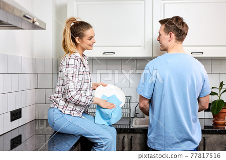 Positive Caucasian Couple Washing Dishes Together Indoors, Keeping House Tidy 77817516