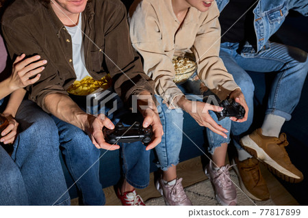 students enjoying of playing in video game having rest at home 77817899