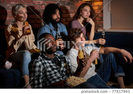 Concerned group of friends worry while watching sport game on tv 77817993