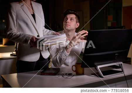 young caucasian man is partial to female colleague, looking at her, in office young caucasian man is partial to female colleague, looking at her, in office 77818056