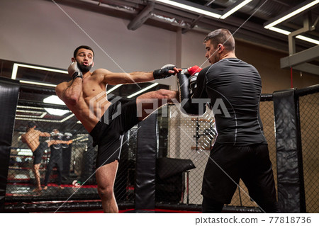 MMA. Two young professional boxers boxing, athletes fighting. Sport, competition, excitement and human emotions concept MMA. Two young professional boxers boxing, athletes fighting. Sport, competition, excitement and human emotions concept 77818736
