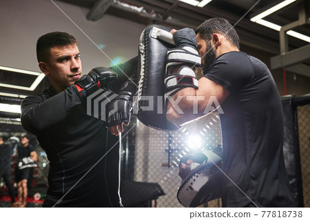 Professional mma fighter teaches self-defense tricks, showing it to young boxer Professional mma fighter teaches self-defense tricks, showing it to young boxer 77818738
