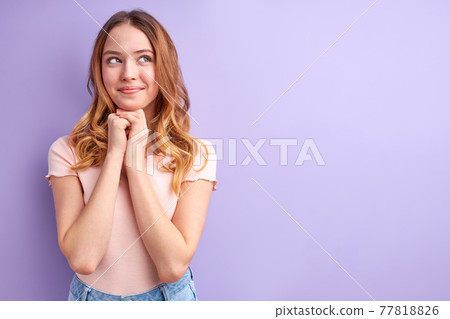 Portrait of Young blonde female with wavy hair looking at side with dreamy face, calm and smiling Portrait of Young blonde female with wavy hair looking at side with dreamy face, calm and smiling 77818826
