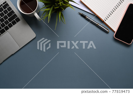 Modern workspace with laptop computer, coffee cup, notebook and smart phone on dark blue leather. Modern workspace with laptop computer, coffee cup, notebook and smart phone on dark blue leather. 77819473