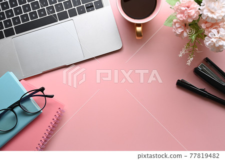 Above view woman workspace with laptop computer, coffee cup, notebook and glasses on pink background. Above view woman workspace with laptop computer, coffee cup, notebook and glasses on pink background. 77819482