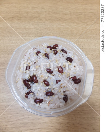 Red rice in a storage container 77820287