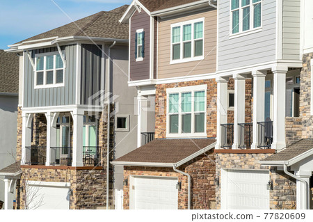 Townhouses with balconies and garages at the facade on a sunny day landscape Townhouses with balconies and garages at the facade on a sunny day landscape 77820609