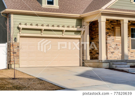 Real estate views on a sunny day with focus on the garage entrance of home Real estate views on a sunny day with focus on the garage entrance of home 77820639