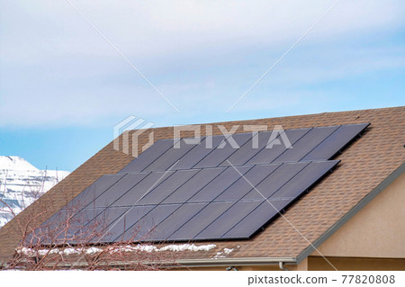 Solar panels on roof of home in Utah Valley against cloudy blue sky in winter Solar panels on roof of home in Utah Valley against cloudy blue sky in winter 77820808