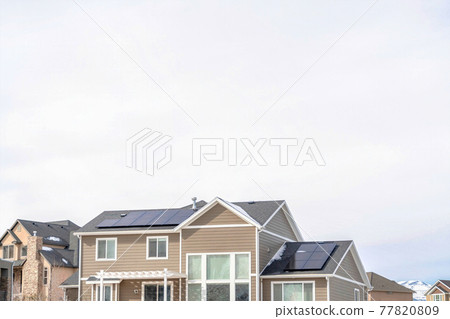 Houses in Utah Valley with solar panels on roofs against cloudy sky in winter 77820809