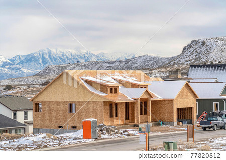 House under construction in Utah Valley against snowy mountain and cloudy sky House under construction in Utah Valley against snowy mountain and cloudy sky 77820812