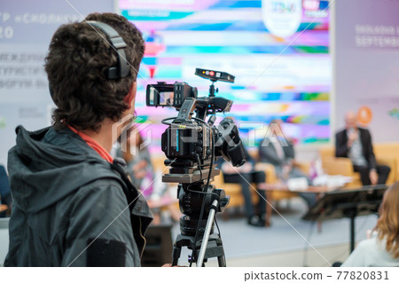 Cameraman shooting video and broadcasting conference 77820831