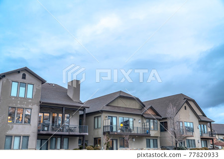 Exterior of houses against dense cloudy sky on a scenic suburban neighborhood Exterior of houses against dense cloudy sky on a scenic suburban neighborhood 77820933