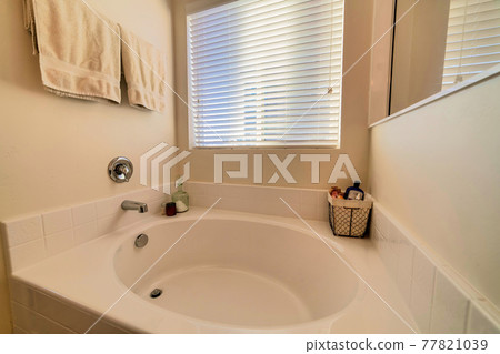 Close up of round built in bathtub inside home bathroom with minimalist design 77821039