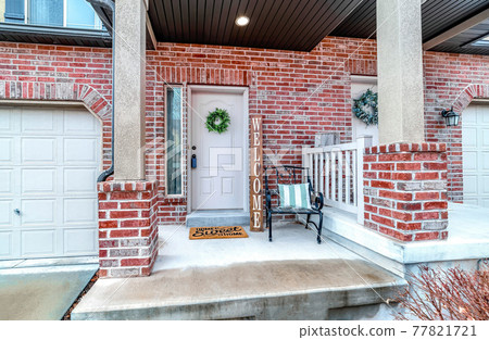 Front of apartment building with white front door and red brick exterior wall 77821721