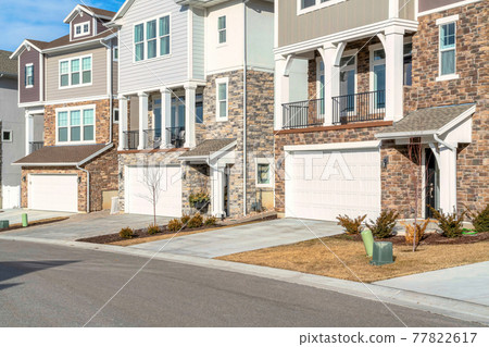 Three storey homes with attached garages and balconies overlooking the road 77822617