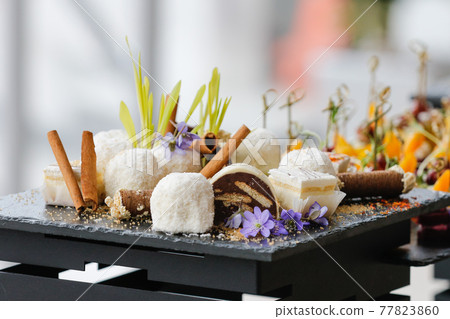 Set of sweet desserts for catering, dessert on a black plate. 77823860