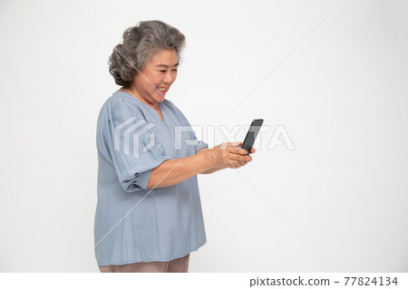 Asian senior woman using smartphone and receiving good news from the message on mobile chat application isolated over white background Asian senior woman using smartphone and receiving good news from the message on mobile chat application isolated over white background 77824134