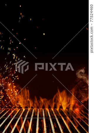 Empty steel barbecue BBQ grill grate with flaming fire, sparks and smoke on black background. Cooking concept. Close up, copy space Empty steel barbecue BBQ grill grate with flaming fire, sparks and smoke on black background. Cooking concept. Close up, copy space 77824460