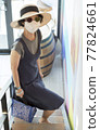 Asian female tourists wear gray clothes, hats, glasses and face masks. 77824661