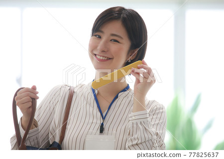 A woman taking out chopsticks from her bag 77825637