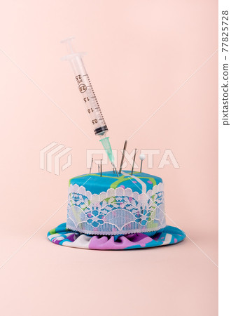 A medical syringe in a needle pad among sewing needles. A medical syringe in a needle pad among sewing needles. 77825728