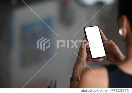 A beautiful woman is using a mobile phone while sitting in the living room. A beautiful woman is using a mobile phone while sitting in the living room. 77825975