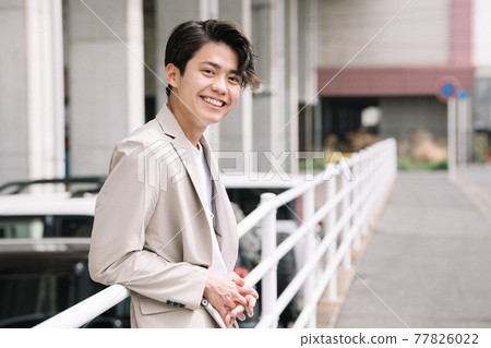 一個微笑的年輕人/穿著夾克的大學生的形象 一個微笑的年輕人/穿著夾克的大學生的形象 77826022