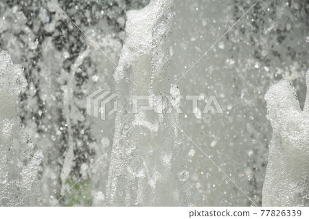 Splash of water gush of water of a fountain abstract background Splash of water gush of water of a fountain abstract background 77826339