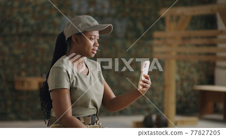 Delighted black military woman speaking with online friend Delighted black military woman speaking with online friend 77827205
