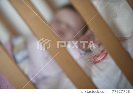 newborn baby sleeping at home in bed 77827798