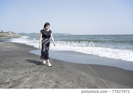 A young woman walking along the beach while being blown by the sea breeze (Nanarigahama, Kamakura City, Kanagawa Prefecture) A young woman walking along the beach while being blown by the sea breeze (Nanarigahama, Kamakura City, Kanagawa Prefecture) 77827972