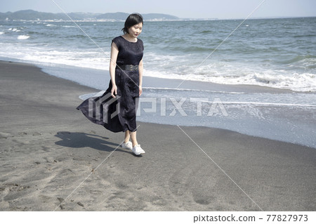 A young woman walking along the beach while being blown by the sea breeze (Nanarigahama, Kamakura City, Kanagawa Prefecture) A young woman walking along the beach while being blown by the sea breeze (Nanarigahama, Kamakura City, Kanagawa Prefecture) 77827973