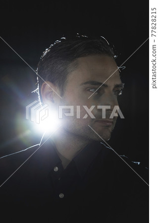 An influencer, artist and musician, dress with black shirt, poses for the camera in one of his photographic shootings for social networks, in a dark backstage area, at night, in Spain. An influencer, artist and musician, dress with black shirt, poses for the camera in one of his photographic shootings for social networks, in a dark backstage area, at night, in Spain. 77828215