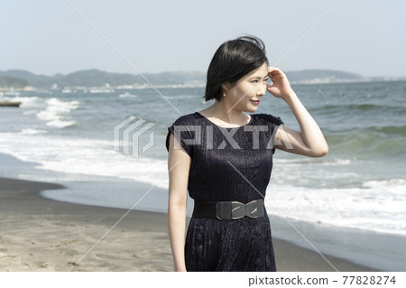 A young woman walking along the beach while being blown by the sea breeze (Nanarigahama, Kamakura City, Kanagawa Prefecture) A young woman walking along the beach while being blown by the sea breeze (Nanarigahama, Kamakura City, Kanagawa Prefecture) 77828274