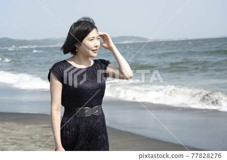 吹著海風在海邊散步的年輕女子（神奈川縣鎌倉市七日濱） 77828276