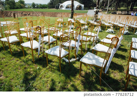 Festive wedding ceremony. Hanging umbrella on an empty chair Festive wedding ceremony. Hanging umbrella on an empty chair 77828712
