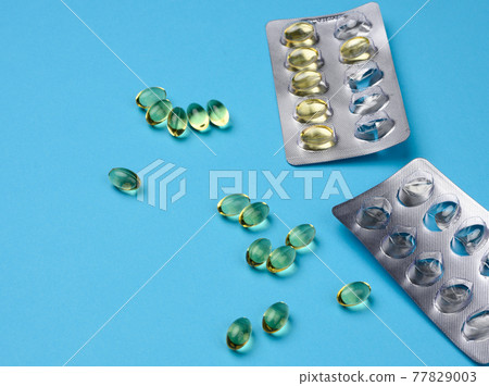 fish oil in capsules and blister pack on blue background, food supplement for health fish oil in capsules and blister pack on blue background, food supplement for health 77829003