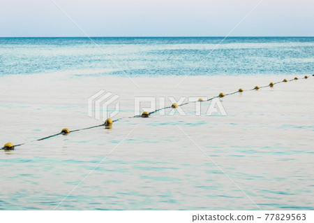 Limiting swimming buoys on the sea background in the evening 77829563